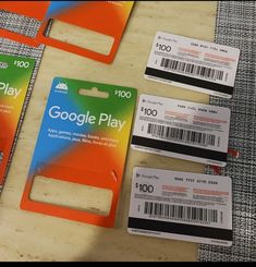 three google play credit cards sitting next to each other on top of a wooden table