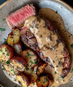 steak with gravy and potatoes on a plate