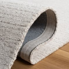 a close up of a rug on the floor with a wooden floor in the background