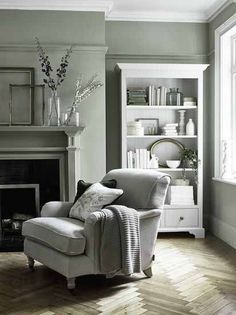 a living room filled with furniture and a fire place in front of a book shelf