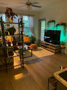 a living room filled with furniture and a flat screen tv sitting on top of a wooden floor