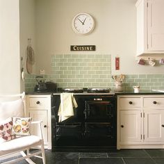 a black stove top oven sitting inside of a kitchen next to white cabinets and drawers