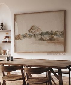 a painting hanging on the wall above a dining room table