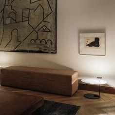 a living room filled with furniture next to a painting on the wall and two lamps