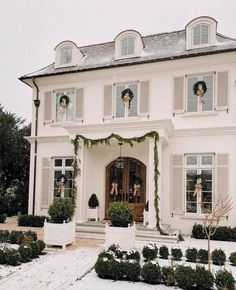 a large white house with wreaths on the windows