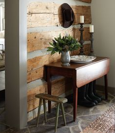 a table with a hat on top of it next to a wall made out of wood planks