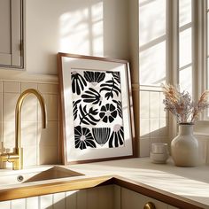 a kitchen sink under a framed art print