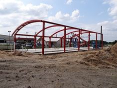 a large metal structure sitting on top of a dirt field