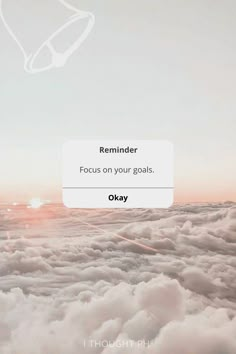 the text reads reminder focus on your goals okay above some clouds and sun in the sky