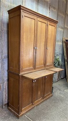 a large wooden cabinet sitting next to a metal wall