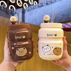 two small jars with bears on them, one is brown and the other is white