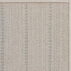 a beige and blue rug with an interesting design on the bottom corner, in two different colors