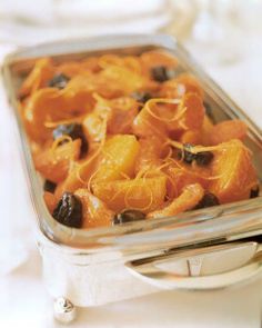 a silver tray filled with oranges and raisins on top of a table