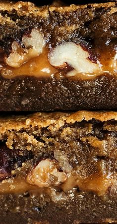 two pieces of brownie with peanut butter and jelly on top, sitting next to each other