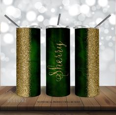 two green and gold canisters with straws in them on a wooden table