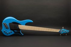 a blue electric guitar sitting on top of a black surface