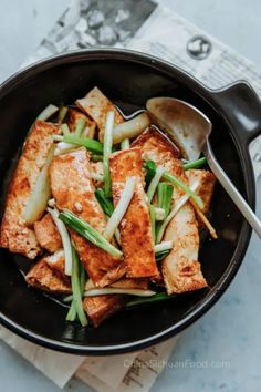 tofu and green beans in a skillet with a spoon on the side, ready to be eaten