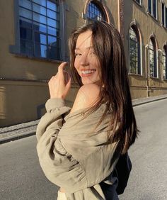 a woman standing on the side of a road with her hand up to her face