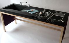 a black counter top with two sinks and various tools on the countertop in front of it