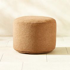 a round ottoman sitting on top of a white tile floor