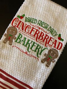 an embroidered dish towel with the words baked fresh daily and gingerbread bakery on it