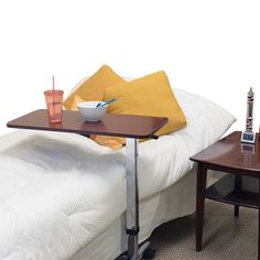 a bed with a tray on top of it next to a table