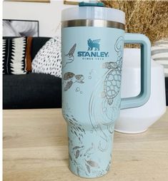 a blue travel mug sitting on top of a wooden table