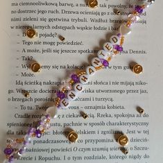 a close up of a book page with beads and charms on the bottom of it