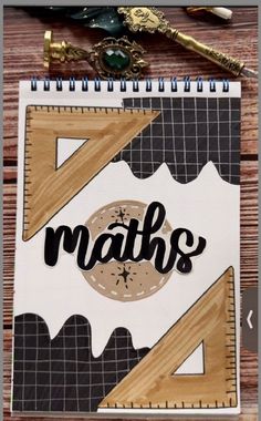 a notebook with the word maths written on it next to a pen and scissors