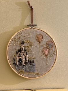 the embroidery is hanging on the wall