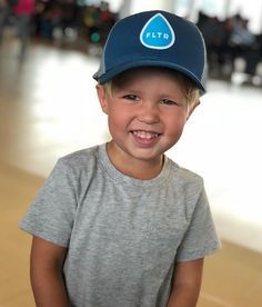 a young boy wearing a hat and smiling