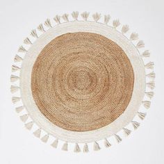 a round woven rug with tassels on top