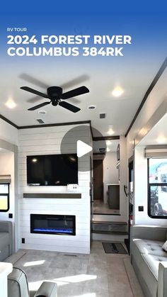 the interior of a travel trailer with white couches and black ceiling fan in it