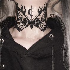 a woman with tattoos on her neck wearing a black hoodie and silver chains around her neck