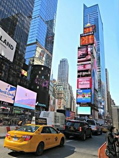 a busy city street filled with lots of traffic and tall buildings covered in billboards