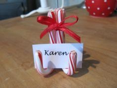 candy canes wrapped in red and white paper with a name tag attached to them