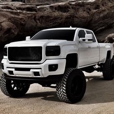 a white truck parked in front of some rocks