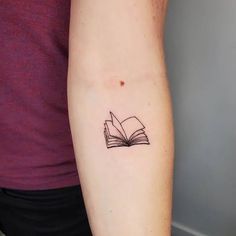 a woman with a book tattoo on her arm