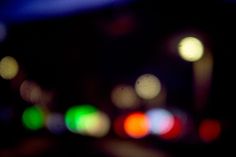 blurry image of city lights at night with focus on the camera lens and blurred background