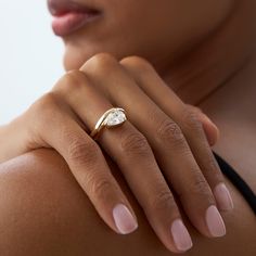 a close up of a woman's hand with a diamond ring on her finger