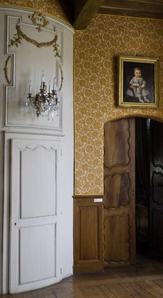 a room with a painting on the wall and a door to another room in it