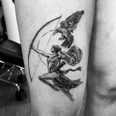 a couple of people that are standing up with some tattoos on their legs and one is holding an arrow