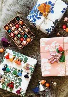 three wrapped presents sitting on top of a fur covered floor next to ornaments and beads