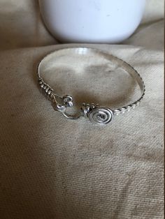 This is a handcrafted bangle/bracelets. It is designed with an oval shape to ensure a proper fit. It is the perfect gift for mothers, sisters, birthdays, daughters, and lovers. This is a simple classy bracelets.  It is  5mm in wide, , handcrafted wire-wrapped bangle bracelet, wire wrapped in sterling silver. A dainty, elegant bracelet that can be used as statement jewelry. As a Caribbean person St.Croix born and raised) these hook-styled bracelets are known to bring good luck or a meaningful ges Sterling Silver Wire Wrapped Bangle Jewelry, Sterling Silver Wire Wrapped Bangle, Handmade Sterling Silver Bangle For Anniversary, Handmade Sterling Silver Bangle In Spiritual Style, Handmade Spiritual Sterling Silver Bangle, Sterling Silver Wire Wrapped Bracelet, Elegant Spiral Wire Wrapped Bracelet, Elegant Spiral Wire Wrapped Bracelets, Elegant Wire Wrapped Spiral Bracelets