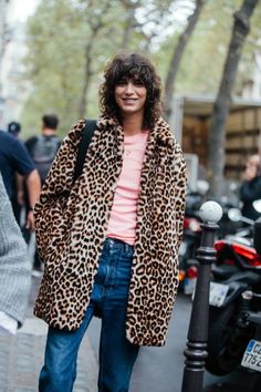 a woman wearing leopard print coat and jeans