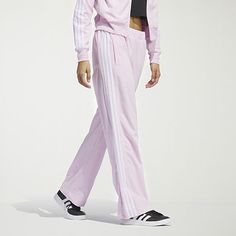 Comfort and style unite with these women's velour 3-stripe tracksuit pants. Designed with a wide leg at the bottom hem and snaps, wear the pant open or tapered based on your style. Featuring three-stripes at the side leg and an elevated gem branding at the wearers left leg, this pant mixes with your favorite pieces and features primegreen trims, echoing our commitment to sustainability.Front Style: Flat FrontClosure Type: DrawstringFit: Regular FitPockets: 2 Front Zip PocketsRise: Mid RiseSupport: Light SupportFiber Content: 100% Recycled PolyesterFabric Description: VelourInseam: 29 1/2 InLeg Style: Straight LegCare: Tumble Dry, Machine WashCountry of Origin: Imported Adidas Three Stripes Pants, Adidas Sporty Wide Leg Sweatpants, Adidas Sporty Wide Leg Pants, Adidas Sporty Wide-leg Pants, Adidas Sporty Wide Leg Bottoms, Adidas Sporty Wide-leg Bottoms, Pink Adidas Pants For Loungewear, Full Length Pants With Side Stripes, Adidas Wide Leg Cotton Pants