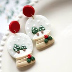 two snow globe earrings with red and green decorations