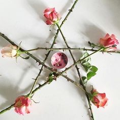 pink roses are arranged in the shape of a pentagram with an inverted star on it