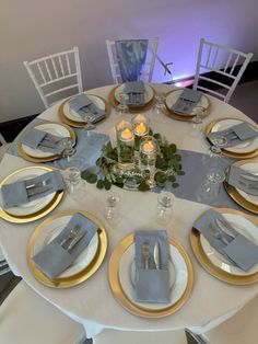 the table is set with silver and gold place settings