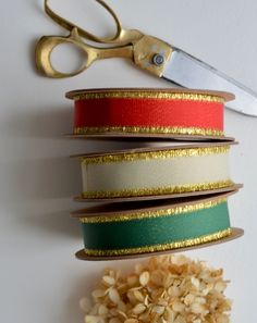 a pair of scissors sitting on top of a table next to some ribbons and flowers